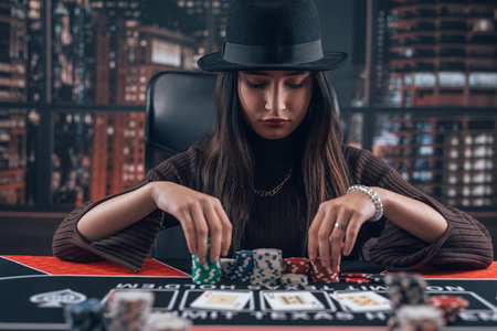 Young pretty caucasian female player in a casino makes bets for big winner. Gambling concept, professional poker gameの写真素材