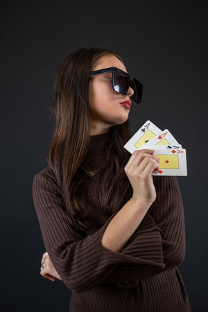 woman holding four aces in her hand isolated on black. Poker or other card gameの写真素材