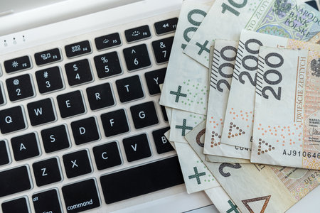 close up of set of Polish PLN banknotes on laptop keyboard. Internet e-commerceの写真素材