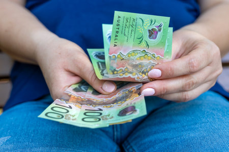 woman holding a bunch of new 50 100 Australian Dollars banknotes. Aussie currency new designed. Saving conceptの写真素材