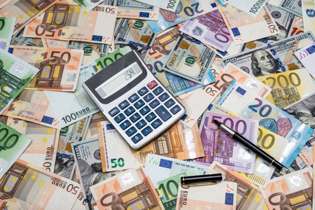 pile od dollar and euro bills with calculator aの写真素材