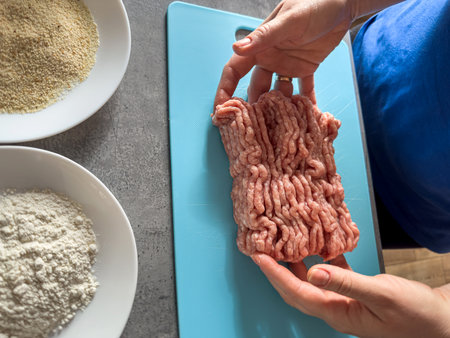 Woman hand knead fresh minced meat close-up, prepare cooking tasty cutlets. Raw foodの写真素材