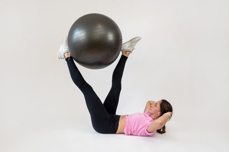 Athletic woman make workout on gym ball on white background. Sport conceptの写真素材