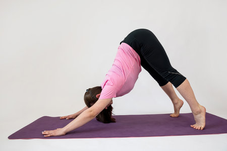 sporty woman doing relax exercise on yoga mat isolated on white. Training yoga lifestyleの写真素材