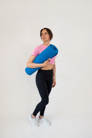 Slim caucasian sport woman hold rubber yoga mat. Sport as healthy lifestyleの写真素材