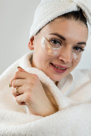 Charming female lady using collagen  patch under eye for clean smoothing  skin isolated on white. Concept beauty treatments.の写真素材