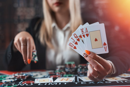 Portrait of gambling lucky woman playing poker with card and chips at casino. Gambling concept, lifestyleの写真素材