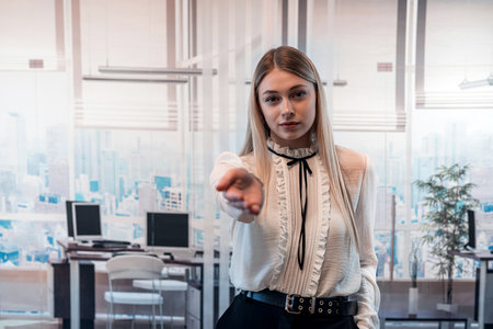 The lady boss, standing in the office, emotionally explains the business plan for the future with the help of her handsの写真素材