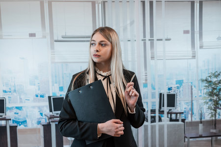 businesswoman in suit or financial concsultant hold clipboard and waiting for a client in the office.の写真素材