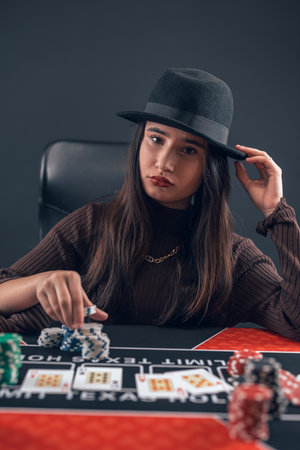 Young female player make bet, raise chips in poker game, change to win. Gambling conceptの写真素材