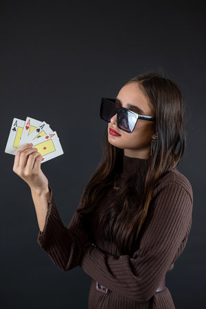 woman holding four aces in her hand isolated on black. Poker or other card gameの写真素材