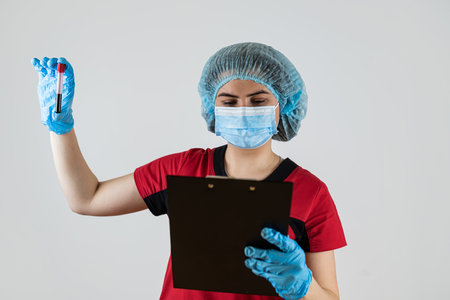 Female doctor hold clipboard and blood testing tube isolated on white. Blood analysisの写真素材