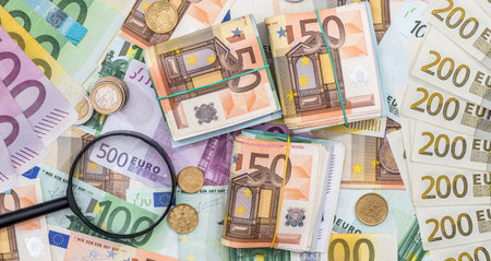 hand magnifier over EU euro paper bills. Economy or debt analysis conceptの写真素材