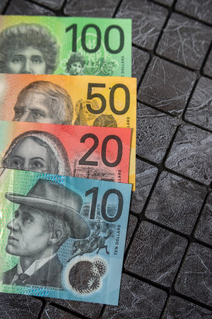 many different new polymer of different denominations Australian dollars banknotes on dark background.の写真素材