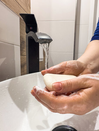 close up Woman washing her hands with soap under the faucetの写真素材