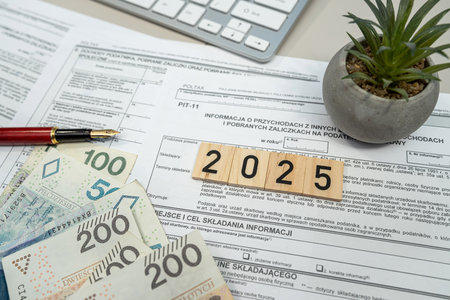 revenues from income tax form PIT-11 with pln zloty money with pen on office table. Concept of...