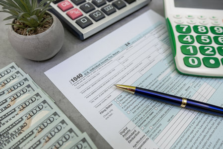 tax form 1040 U.S. Individual Income Tax Return with pen, notebook and dollar bills. Tax time conceptの写真素材