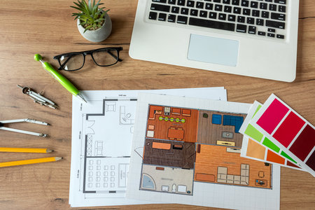 laptop to create house plan with color palette, architectural blueprint on office desk. Concept of...