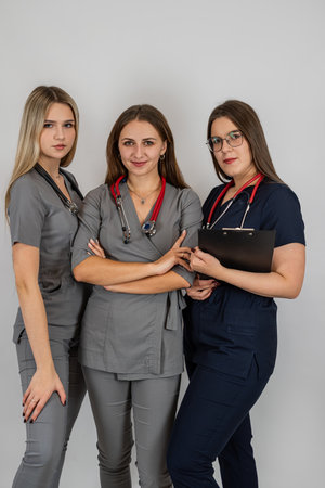 Three female doctors wear uniform with stethoscope posing isolated studio shot. Healthcare and medical concept.の写真素材
