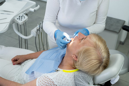 Female dentist examining a female senior patient teeth in dental office. Healthy lifestyleの写真素材