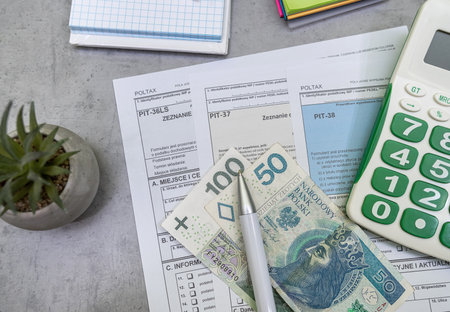 Declaration of polish tax form PIT-37 and PIT-38 with pln zloty pen and calculator on accountant table. Tax time. Accounting conceptの写真素材