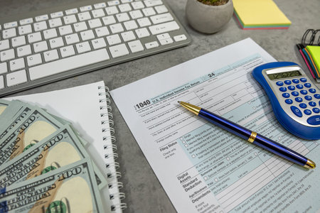 American income returns tax form 1040 calculator pen dollar bills . Time for tax, accounting documents from USA aの写真素材