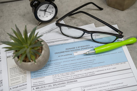 example Polish tax form PIT-38, PIT-37 PIT-36L pen calculator glasses on desk. Lump sum recorded on revenuesの写真素材