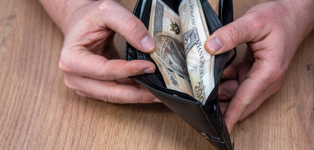 male hands take out pln zloty banknotes from leather black purse, saving concept, currency exchange...