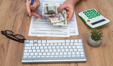 man count polish zloty money when fill tax form PIT-37 for individual tax return. Taxation concept aの写真素材