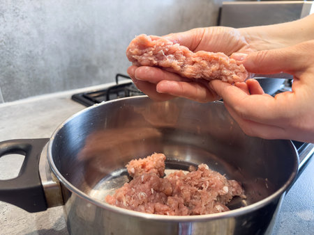 close up female hands grind minced meat for fresh meatballs. Raw fresh minced meatの写真素材