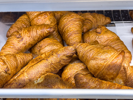 Fresh baked croissants with cream on a shelf. Bakeryの写真素材
