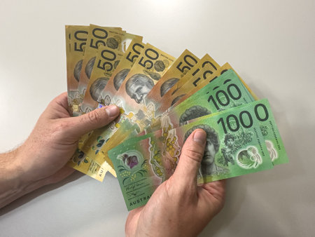 Close up of a man counting new 50 100 Australian Dollar Notes in hand. Australian money concept of savingの写真素材