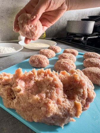 Female hand prepare meatballs cutlets with raw meat on the kitchen table. Uncook foodの写真素材