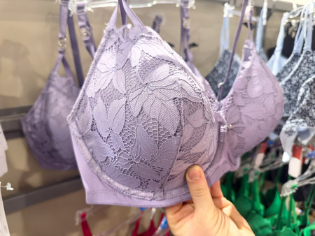 Woman choosing bra in lingerie store, closeup. Lace lingerie textile, underwear.の写真素材