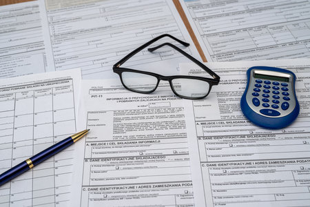 Calculating taxes in Poland, Pit different form with pen calculator glasses on desk business income