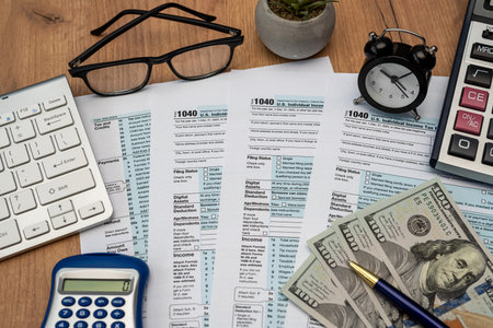 glasses, pen, dollars and tax form 1040 pen calculator on desk. Taxation, tax burden. Annual reportの写真素材