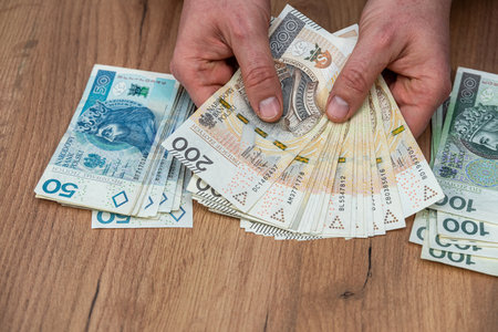 business man holds pln zloty money banknotes on desk, payment cash concept. Financial