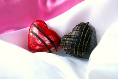 Two Chocolate Hearts on White Satinの写真素材