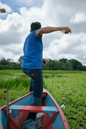 Adult fishing on traditional wooden canoe, Amazon natural reserve. High quality photo
