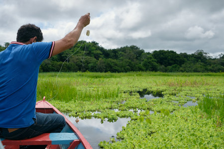 Adult fishing on traditional wooden canoe, Amazon natural reserve. High quality photoの写真素材