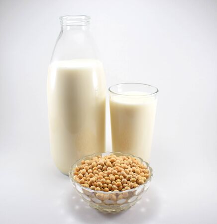 Bottle and glass of soy milk, bowl with soy beansの写真素材