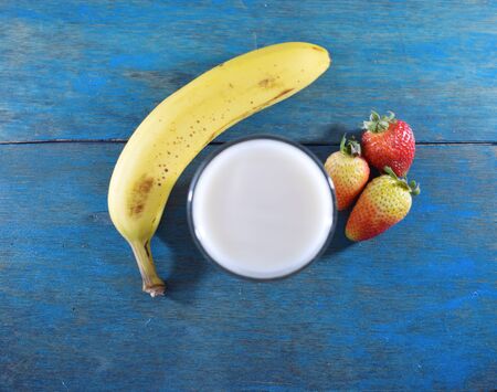 Glass of milk, banana and strawberriesの写真素材