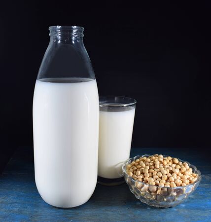 Bottle and glass of soy milk, bowl with soy beansの写真素材