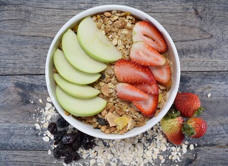 Bowl of cereal, oats, raisins, strawberry and appleの写真素材