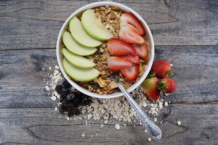 cereal bowl with oatmeal, raisins, strawberries and applesの写真素材