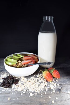 Bowl with cereal and fruits, bottle of milkの写真素材