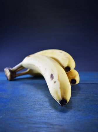Bunch of banana on wooden table and black backgroundの写真素材