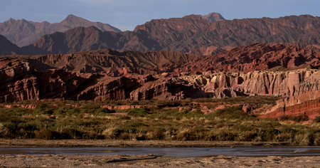 Sunset over the valley surrounded by the river and the mountains in the backgroundの写真素材