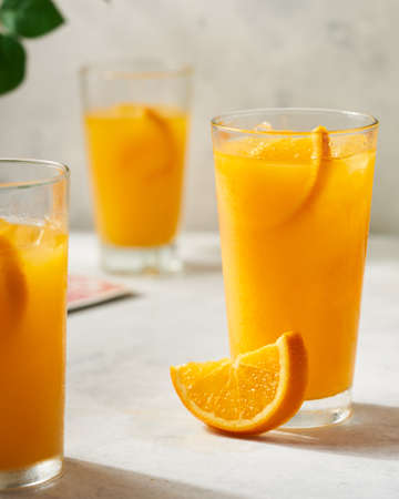 summer snack with three orange juice and cut slices to eatの写真素材