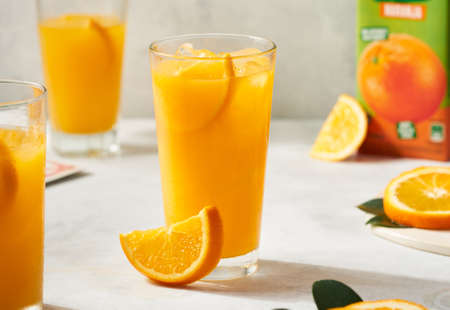 summer snack with orange juice, cut slices and card gamesの写真素材